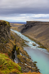 Fototapeta na wymiar Beautiful landscape of Sigoldugljufur canyon with many small waterfalls and the blue river in Highlands of Iceland