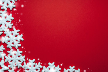 red background with white snowflakes and stars. place for text with christmas decorations