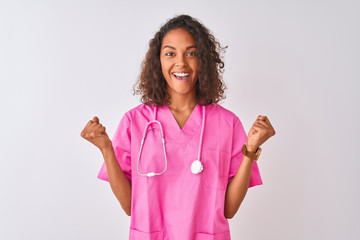 Young brazilian nurse woman wearing stethoscope standing over isolated white background celebrating...