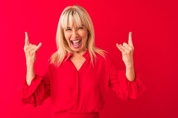 Middle age woman wearing elegant shirt standing over isolated red background shouting with crazy...