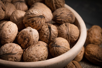 Whole walnuts in a wooden bowl.