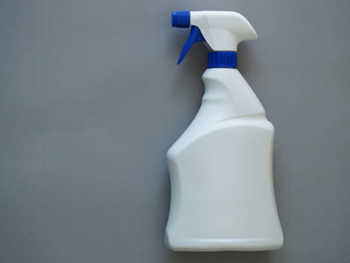 White spray bottle on a gray background with place for text.