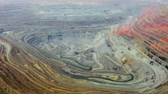 Aerial view of opencast mining quarry with lots of machinery at work - view from above.