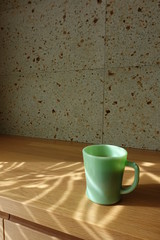 テーブルに置かれたコーヒーカップ　カーテン越しの光の中で　cup of coffee on table