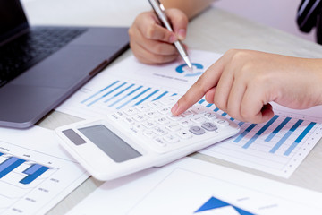 Business financial and investment concepts, people using calculators and data graphs to analyze company revenue and expenditures in preparation for the planning of presentations, finances concept