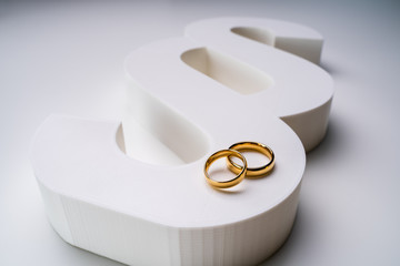 White Paragraph Sign And Golden Wedding Ring Over White Surface