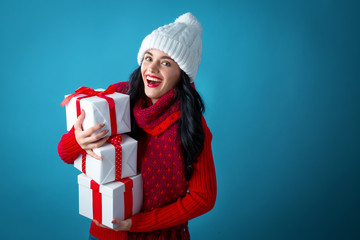 Young woman with gift boxes on a dark blue background
