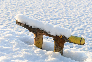 Bollard and pier covered with snow