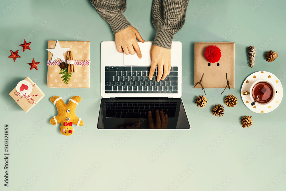 Wall mural Christmas giftboxes with person using a laptop computer - overhead view