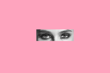 Cut out girl's eyes black and white on a pink isolated background. Concept - search for yourself...