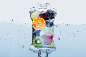 Fruit Slices In Saline Bag Dipped In Water Against Background - obrazy, fototapety, plakaty