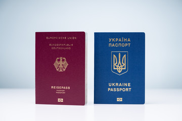 German And Ukrainian Passports Against White Surface