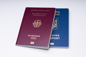 German And Ukrainian Passports Against White Surface