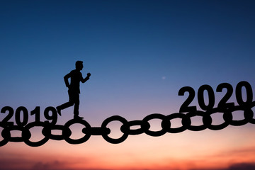 Silhouette of business man walking and running on chain bridge from 2019 to 2020 new year of success