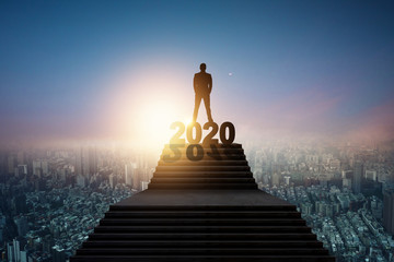 Success and leader of future concept, silhouette of businessman standing on 2020 new year letter on...