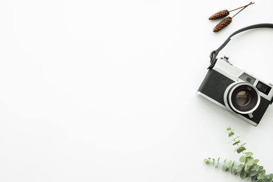 White minimal hipster photographer office desk table with retro film camera. Top view with copy space, flat lay.