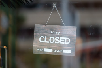 sorry we are closed sign hanging outside a restaurant, store, office or other