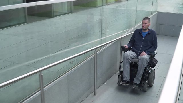 4k resolution follow of a man on electric wheelchair using a ramp. Accessibility concept