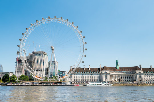 London, UK - June 25, 2018: Cityscape on Thames river by London Eye, City Hall at Victoria Embankment in sunny summer