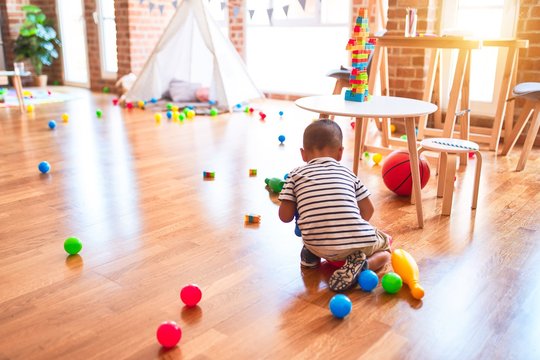 Beautiful toddler boy playing bowling at kindergarten
