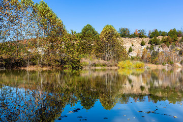 Fototapeta na wymiar trees and rocky bluff reflected in a lake