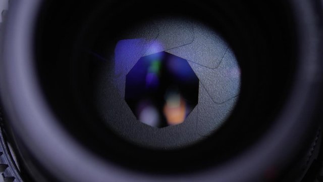 Rotating camera lens showing close up view of aperture iris blades