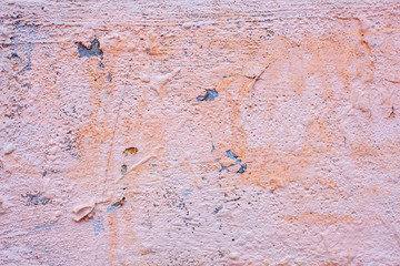pink, cracked paint on old wall crumbling houses
