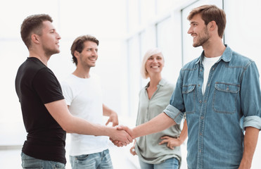 Obraz premium coworkers shaking hands in the office lobby.