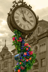 Fototapeta na wymiar Floral decorations with old clock in Timisoara, Romania