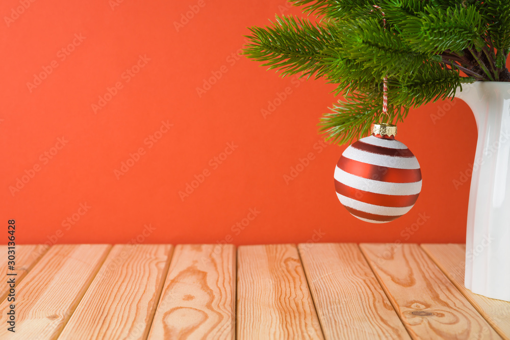 Wall mural Christmas holiday background with bauble decoration and fir tree branches on wooden table