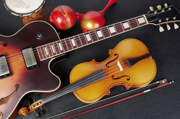 Fototapeta na wymiar Electric guitar and violin on a dark background. Close-up