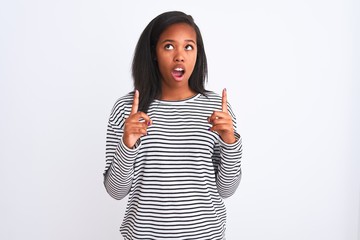 Beautiful young african american woman wearing winter sweater over isolated background amazed and...