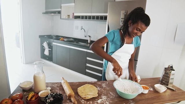 Young family cooking food in kitchen. Happy Little girl with her mother mixing batter. Mother and Little boy preparing the dough. Happy family in the kitchen and junior chef Concept. Cinematic 4k.