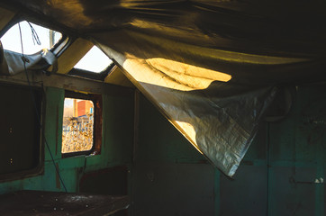 Inside an old and abandoned van with broken windows, beautiful light from the windows