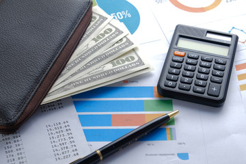 Financial reports on the table, business attributes, pen and calculator with banknotes in the wallet. Business growth concept background for business and money
