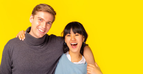 Naklejka premium Portrait adorable romantic fellow bonding best friend, soulmate or lovely young couple. enjoying each other placing arms around neck together. happiness, laughing together copy space yellow background