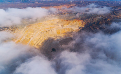 Aerial view of opencast mining quarry with lots of machinery at work - view from above.