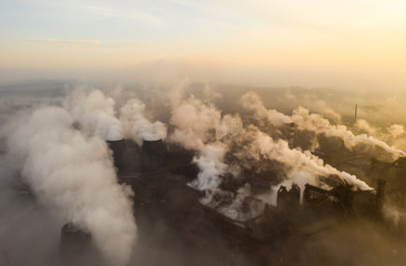 Aerial view. Pipes Throwing Smoke in the Sky. Large Plant on the Background of the City.
