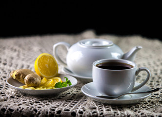 Obraz na płótnie Canvas cup of tea with lemon and teapot