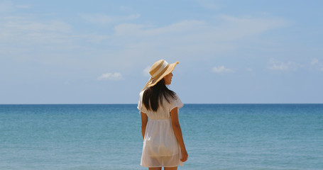 Fototapeta na wymiar Woman with straw hat look at the sea