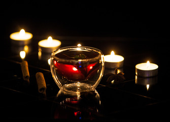 tea with cinnamon in a transparent glass and candles