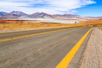 Fototapeta na wymiar Deserted aphalt road in a landscape of the majestic Andes mountain range in Bolivia, South America