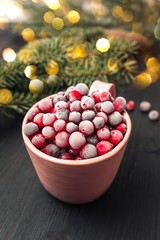 Cup with fresh frozen berries, bokeh lights on background