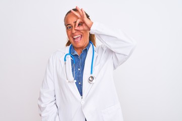 Middle age mature doctor woman wearing stethoscope over isolated background doing ok gesture with hand smiling, eye looking through fingers with happy face.