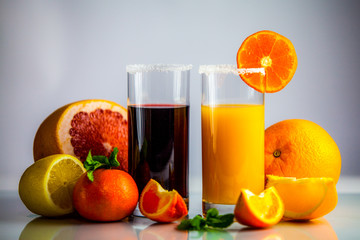 a glass of orange juice with a straw and orange