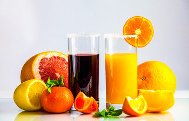 a glass of orange juice with a straw and orange