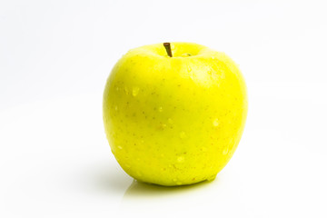 Wet green apple with drops on a white background. close up