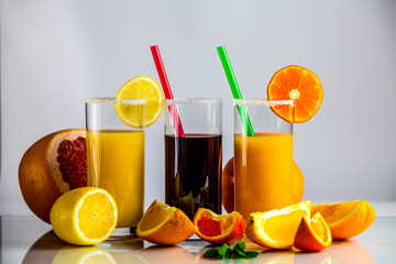 a glass of orange juice with a straw and orange