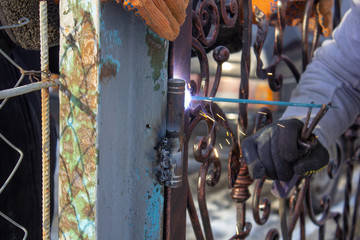 work with welding gates,Workers welding, fixing the gate. Welding spark. industrial workers welding.