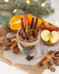 Different fruit leather in a glass. Sprigs of spruce, garland, oranges, apples, nuts in the background